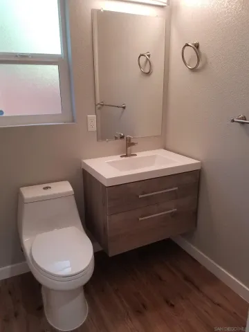 a bathroom with a toilet sink and mirror