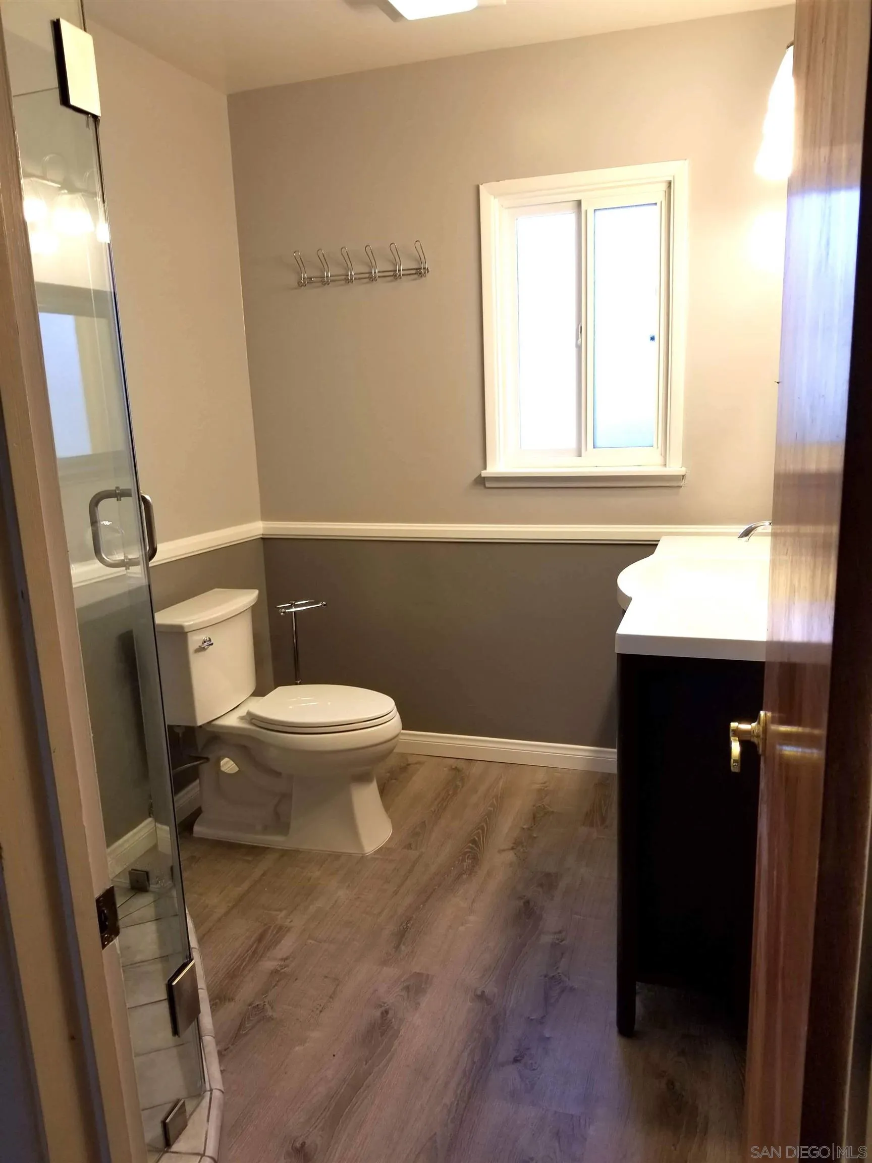 5051 63rd Street San Diego, CA 92115 - Photo 10 of 28 a bathroom with a toilet a sink a window and mirror