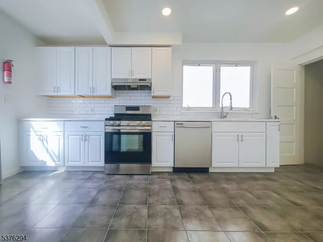 a kitchen with a stove top oven sink and cabinets