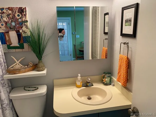 a bathroom with a toilet sink and mirror