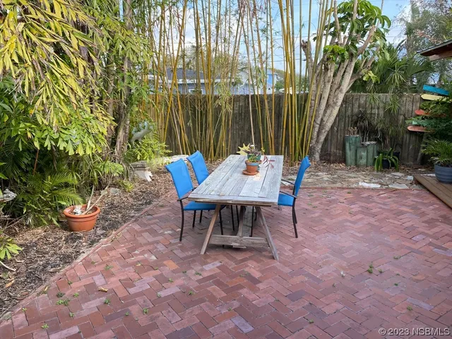 a view of a tables and chairs in back yard of a house