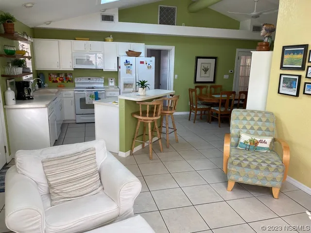 a living room with furniture and a dining table with kitchen view