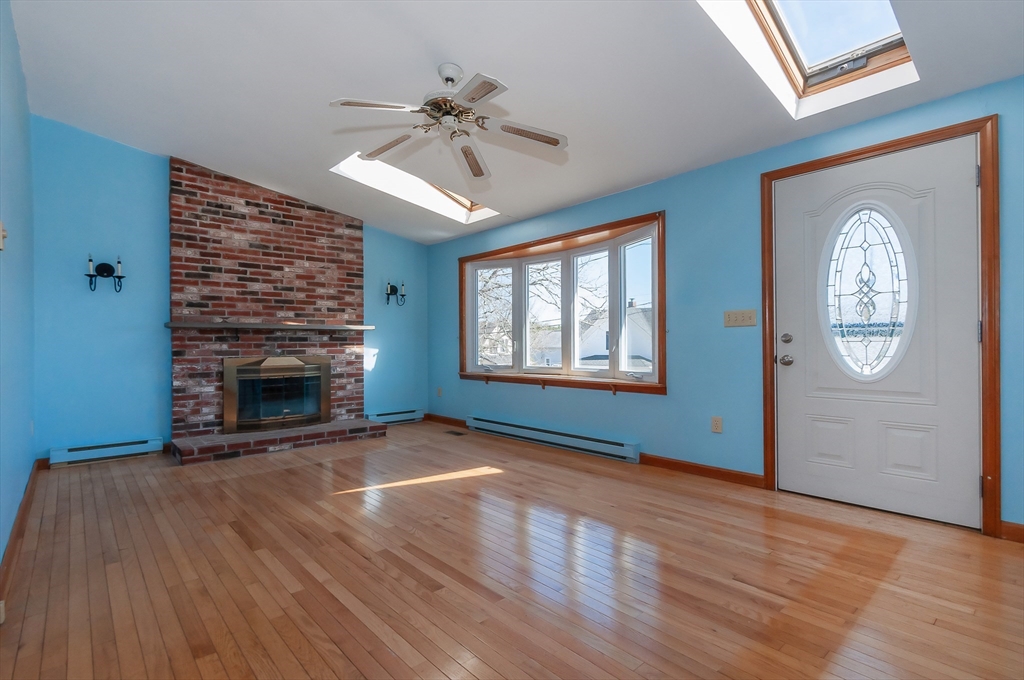 7 Roosevelt Street Wareham, MA 02571 - Photo 7 of 29 wooden floor fireplace and windows in an empty room