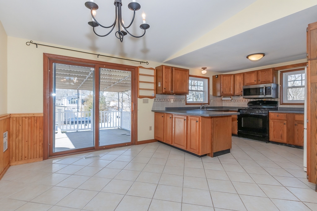 7 Roosevelt Street Wareham, MA 02571 - Photo 10 of 29 a large kitchen with stainless steel appliances granite countertop a stove top oven a sink dishwasher a dining table and chairs with wooden floor