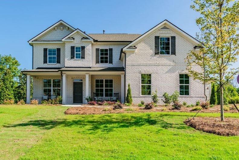 a front view of a house with yard and green space