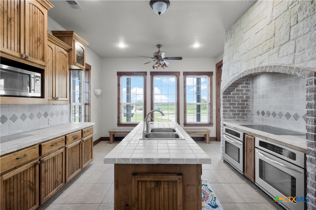 12491 Madison Lane Justin, TX 76247 - Photo 19 of 38 a large kitchen with granite countertop a stove and a sink