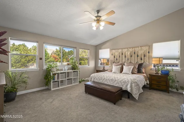 a bedroom with a large bed and a chandelier fan