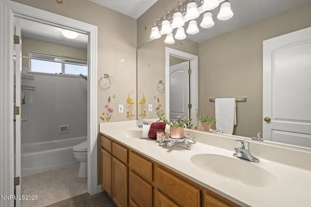 a bathroom with a double vanity sink mirror and toilet