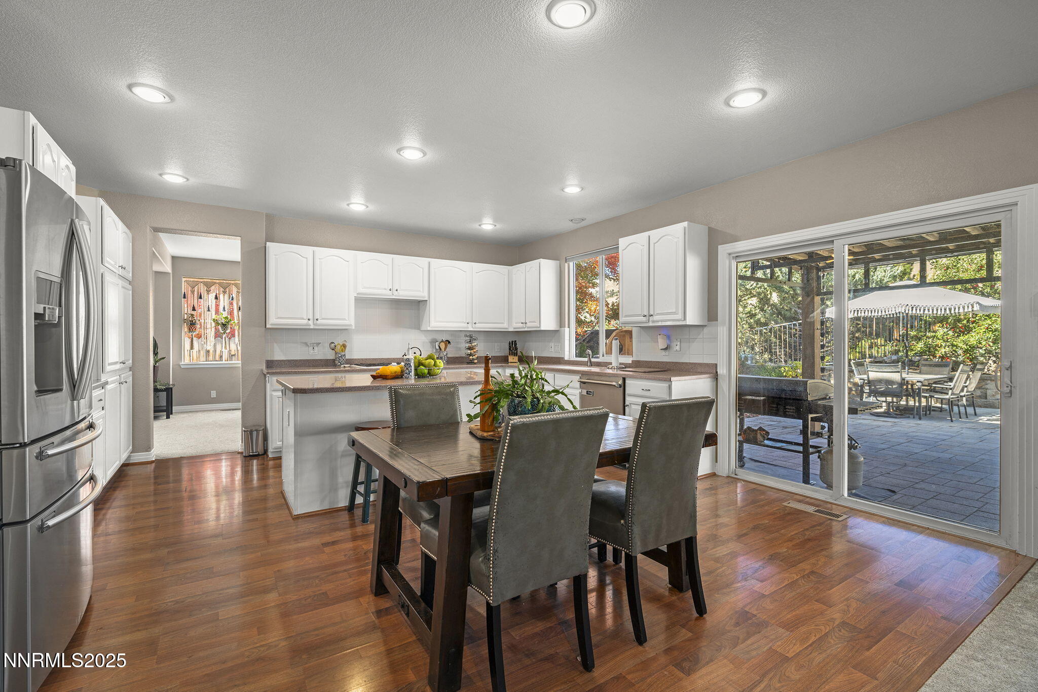 7159 Windstar Drive Reno, NV 89523 - Photo 9 of 33 a kitchen with stainless steel appliances granite countertop a refrigerator a stove top oven a sink island and chairs with wooden floor