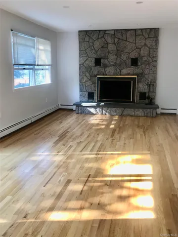 a view of empty room with wooden floor and fireplace