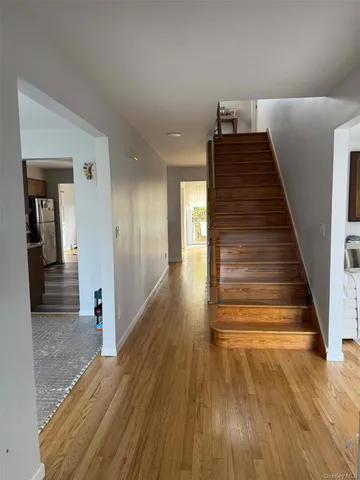 a view of a hallway with wooden floor and stairs