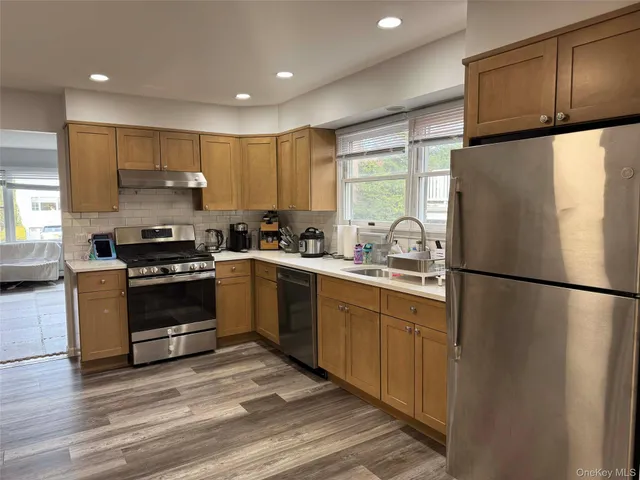 a kitchen with a refrigerator sink and cabinets