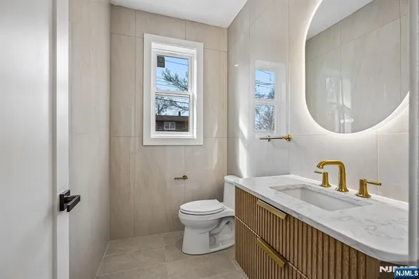 a bathroom with a granite countertop toilet a sink and a mirror