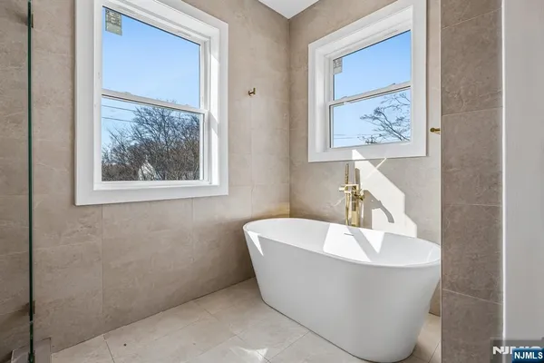 a white tub sitting next to a bathroom