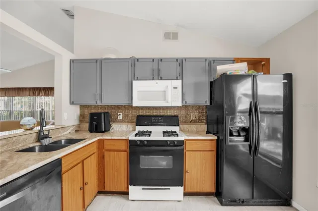a kitchen with cabinets appliances a sink and a counter top
