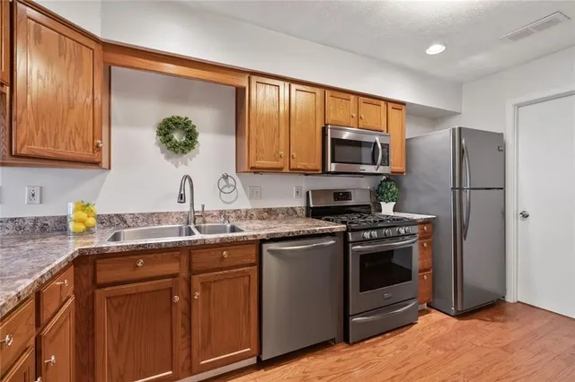 a kitchen with granite countertop wooden floors and refrigerator