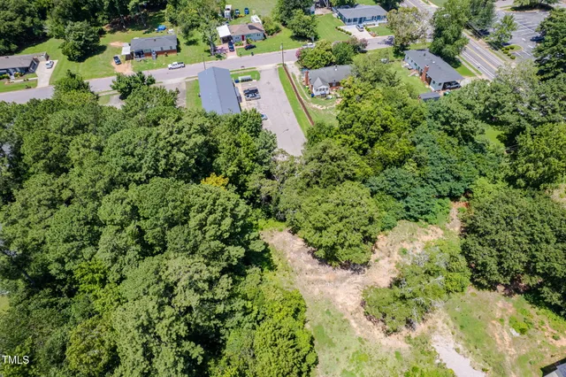 an aerial view of residential house with outdoor space and trees all around
