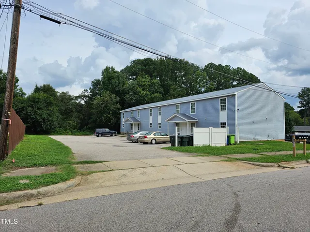 a white house that has tree in front of it