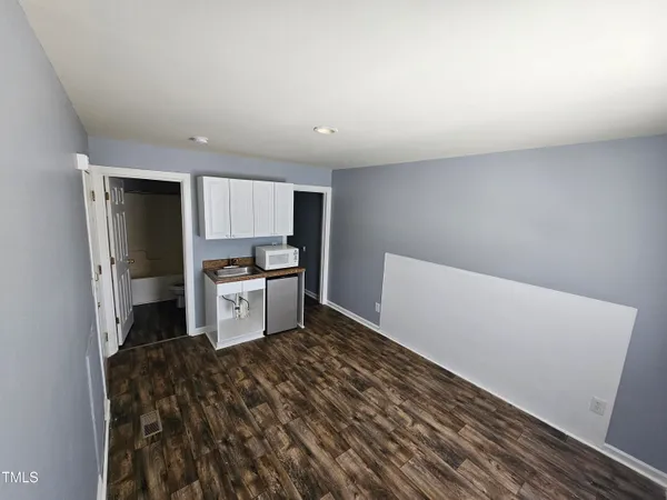 a kitchen with a refrigerator and white cabinets