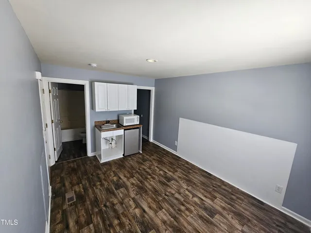 a kitchen with a refrigerator and white cabinets