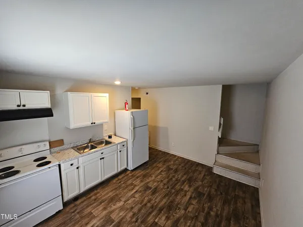 a kitchen with white cabinets and white appliances