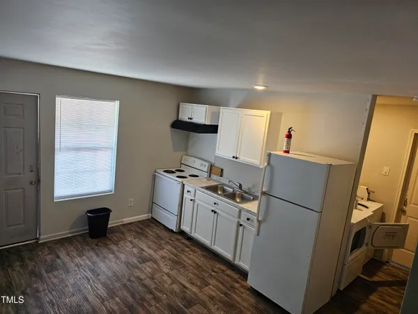 a kitchen with sink a refrigerator and a stove top oven
