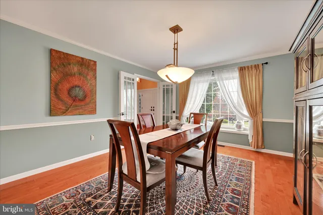 a dining room with furniture a chandelier and wooden floor