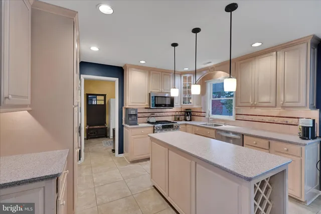 a kitchen with stainless steel appliances kitchen island granite countertop a sink a stove and a refrigerator
