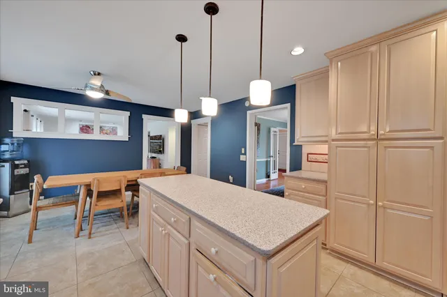 a kitchen with a table chairs wooden floors and a view of kitchen