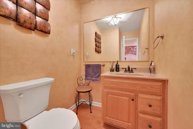 a bathroom with a granite countertop toilet sink and mirror