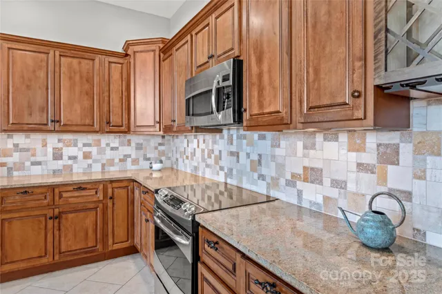 a kitchen with stainless steel appliances granite countertop a sink a stove and cabinets