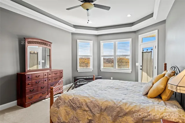a bedroom with a bed a chandelier and a dresser