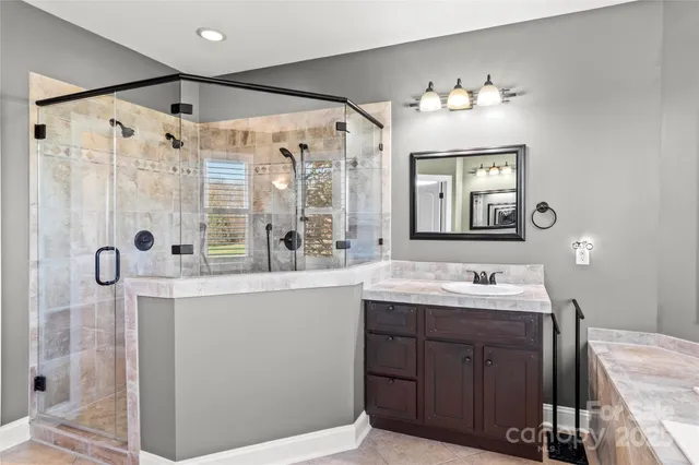 a bathroom with a double vanity sink mirror and shower