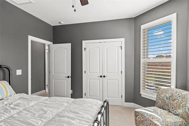 a bedroom with a bed closet and a large mirror