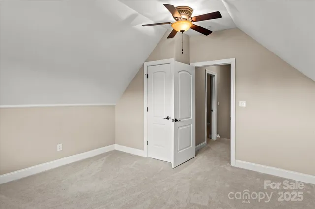 an empty room with closet and a ceiling fan