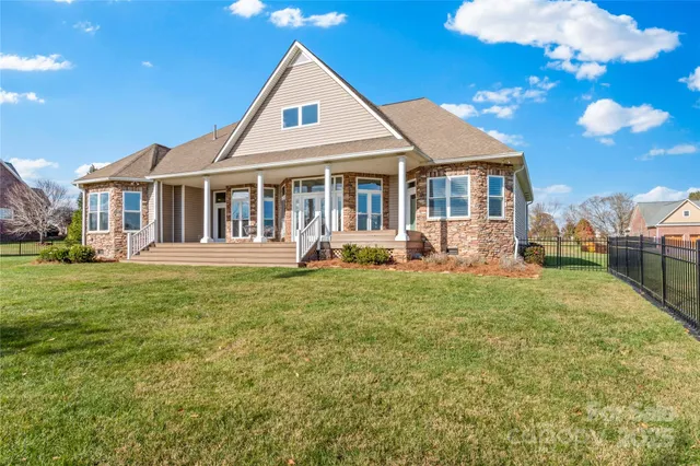 a front view of a house with a garden and trees