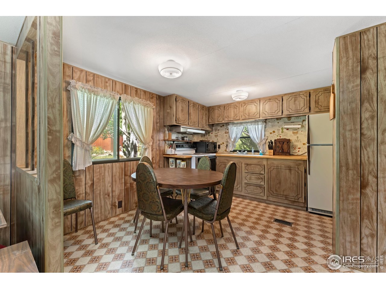 277 Riverside Drive Bellvue, CO 80512 - Photo 12 of 23 a kitchen with a table chairs refrigerator and cabinets