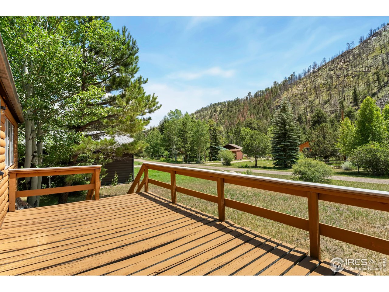 277 Riverside Drive Bellvue, CO 80512 - Photo 6 of 23 a view of a balcony with wooden floor and bench