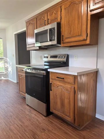 a kitchen with stainless steel appliances granite countertop a stove microwave and refrigerator