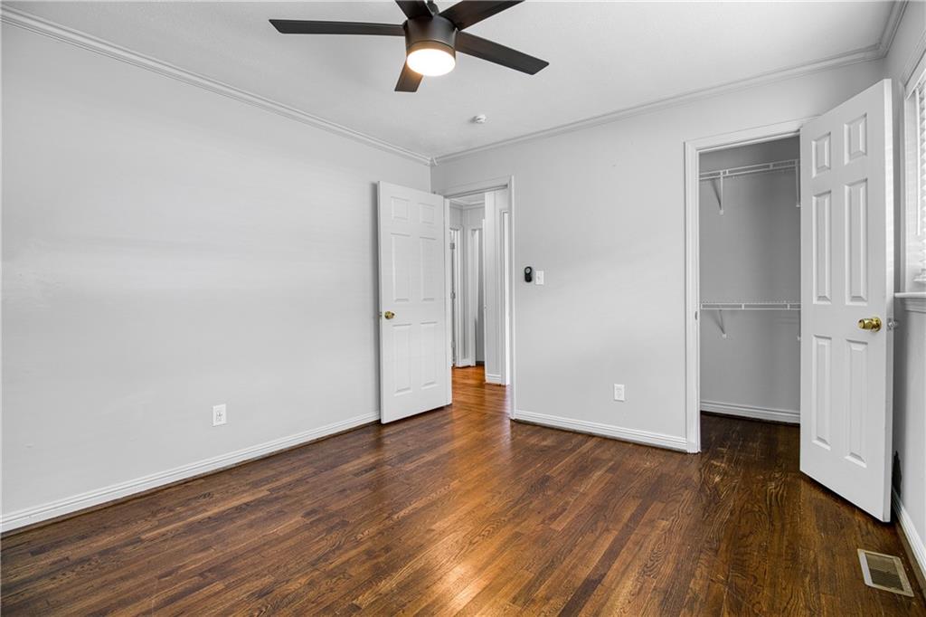 3447 Pierce Street Atlanta, GA 30337 - Photo 14 of 28 an empty room with wooden floor a ceiling fan and a window