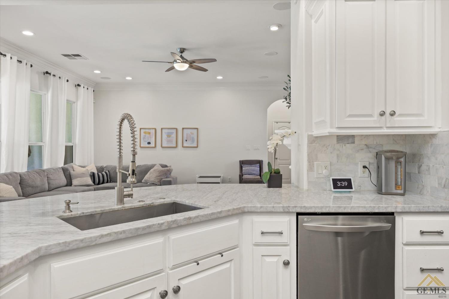 Undisclosed Address Bakersfield, CA 93311 - Photo 22 of 45 a kitchen with stainless steel appliances granite countertop a sink dishwasher and white cabinets with wooden floor
