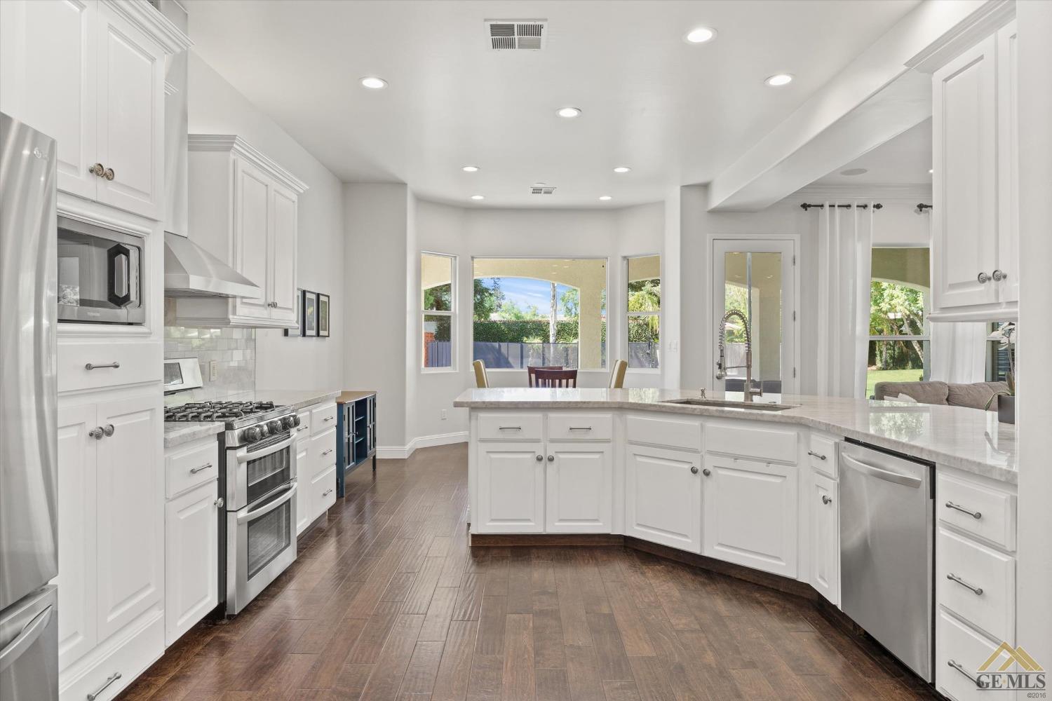 Undisclosed Address Bakersfield, CA 93311 - Photo 23 of 45 a large white kitchen with stainless steel appliances granite countertop a stove and a sink