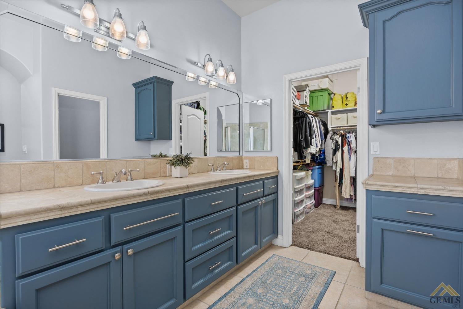 Undisclosed Address Bakersfield, CA 93311 - Photo 28 of 45 a spacious bathroom with a granite countertop sink a light fixture and a mirror