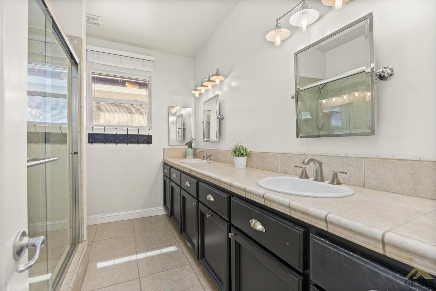Undisclosed Address Bakersfield, CA 93311 - Photo 31 of 45 a bathroom with a double vanity sink and a mirror