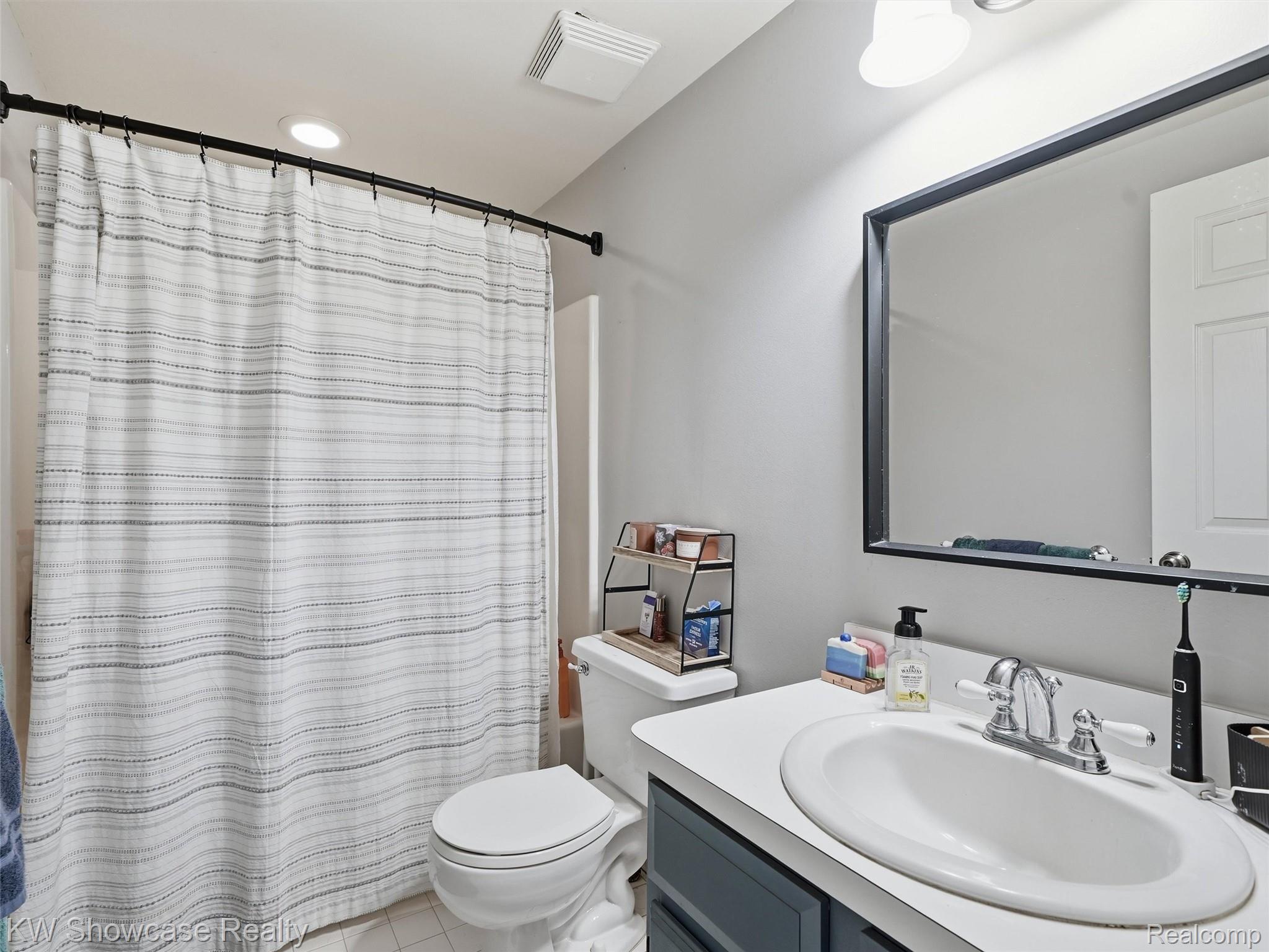 3360 Pleasant Valley Road Brighton, MI 48114 - Photo 36 of 60 Bathroom vanity with an integrated oval sink, chrome faucet, and expansive wall-mounted mirror