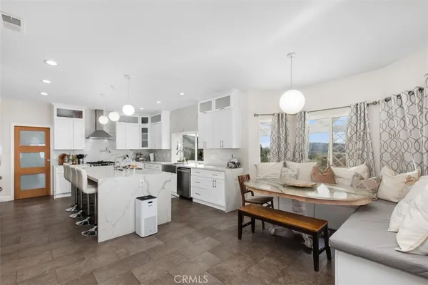 a large white kitchen with lots of counter space and furniture