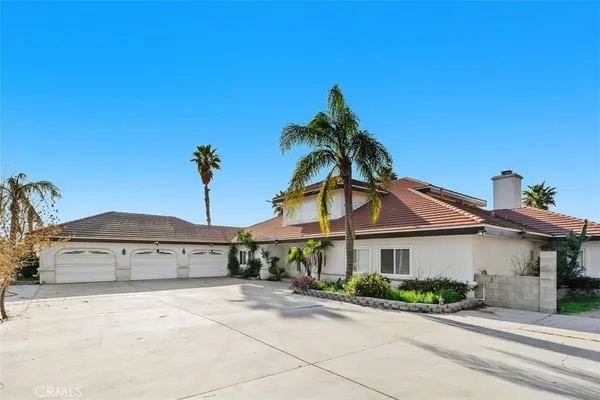 a view of a house with a yard and potted plants