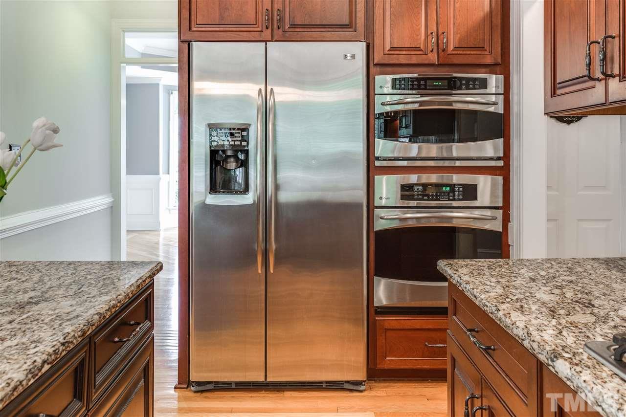 8401 Largo Springs Court Raleigh, NC 27613 - Photo 11 of 25 a metallic refrigerator freezer sitting inside of a kitchen