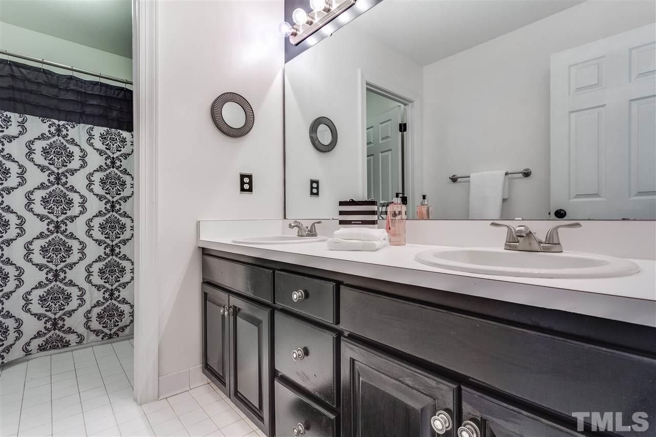8401 Largo Springs Court Raleigh, NC 27613 - Photo 18 of 25 a bathroom with a double vanity sink and a mirror