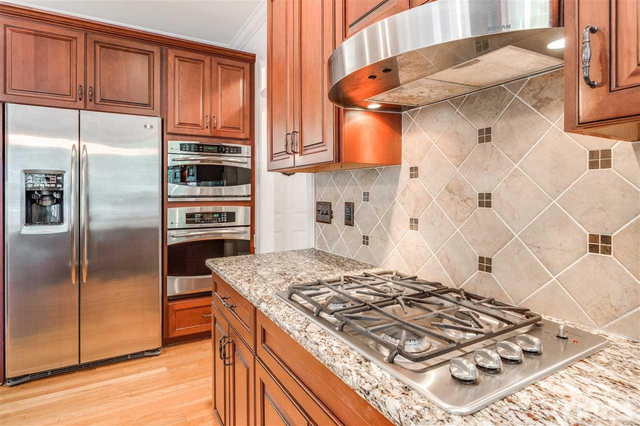 8401 Largo Springs Court Raleigh, NC 27613 - Photo 10 of 25 a kitchen with stainless steel appliances granite countertop a sink stove and refrigerator